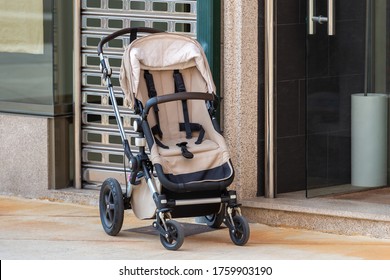 Empty Baby Stroller Near The Open Entrance To The Store