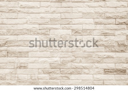Empty background of wide cream brick wall texture. Beige old brown brick wall concrete or stone textured, wallpaper limestone abstract flooring. Grid uneven interior rock. Home decor design backdrop.