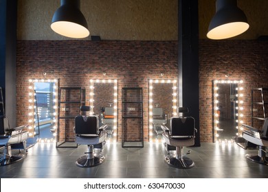 Empty barbershop with places for hairdresser and make-up artist work - seats and mirror with illumination