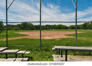 Empty Baseball Field Behind a Chain-Link Fence on a Sunny Summer Day