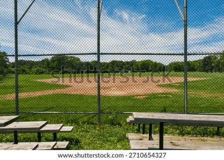 Empty Baseball Field Behind a Chain-Link Fence on a Sunny Summer Day