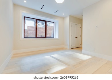 Empty basement or ground level room room in a newly built house with window overlooking backyard
