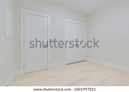 Empty basement or ground level room room in a newly built house with door closed and closet door