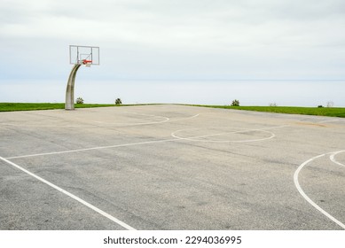 Empty basketball court overlooking the ocean on a cloudy and foggy autumn morning