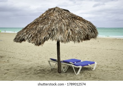 Empty beach beds under the straw hut