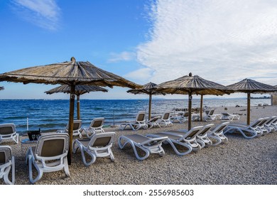 Empty beach cafe without visitors after the end of the season, reed sunshades, empty sunbeds, Adriatic Sea, Croatia