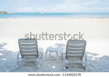 empty beach chair over looking the clear blue sky and ocean 