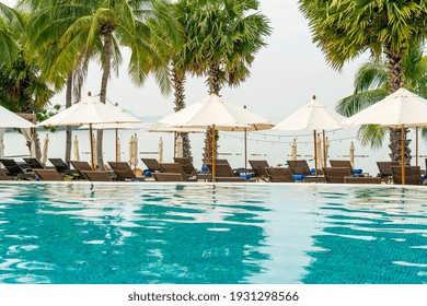 Empty Beach Chair With Umbrella Around Swimming Pool