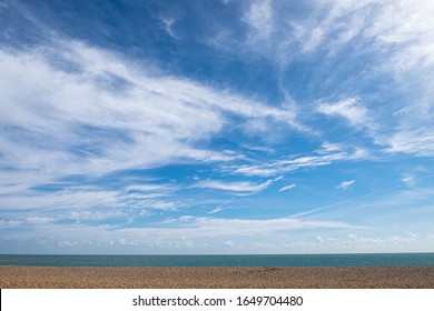 Empty beach with horizon, blue sky and wispy cloudscape. Aldeburgh, Suffolk UK. 