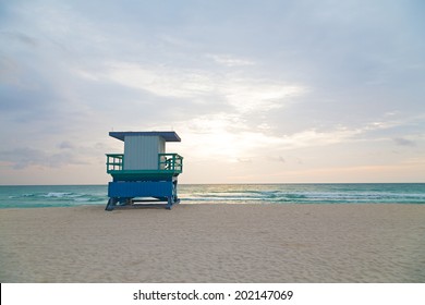 Empty beach with lifeguard cabin at sunrise. A lonely cabin on the empty beach. - Powered by Shutterstock