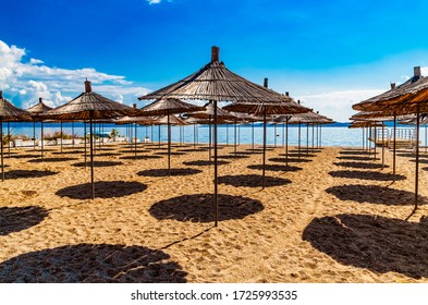 Empty beach with reed beach umbrellas, nobody on the beach. Beautiful blue sky, hot weather. Beach with no travellers and tourists. Cancellations due to coronavirus covid-19. Quarantine.