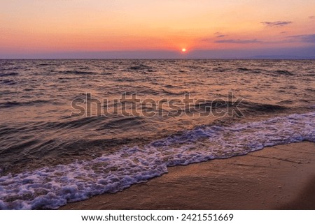 empty beach with the waves and beautiful  sunset. wavy sandy beach. Blue sky with natural white clouds