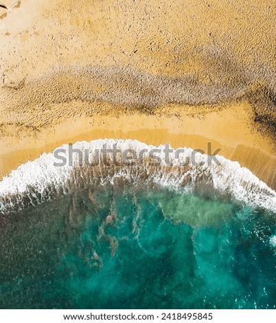 Empty beach with waves and white sand from drone view