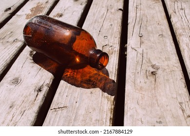 Empty beer bottle on weathered deck boards