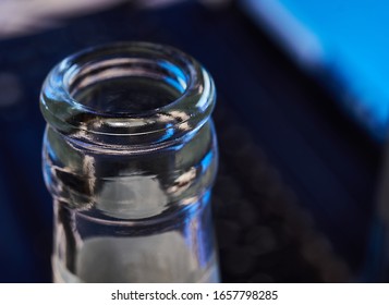 Empty Beer Bottle, Upper Part, In Front Of The Keyboard Of A Laptop. Selective Sharpness. Concept For Alcohol Abuse And Alcohol Dependency At The Workplace