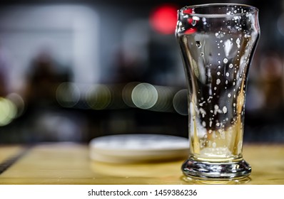Empty beer glass on bartop 