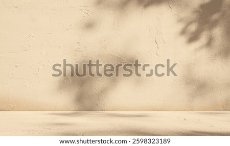 Empty beige background with sunlight superimposed shadow leaves on the wall. autumn background template for product presentation concept	