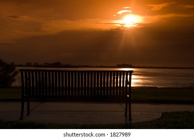 empty bench at the beach front at sunset