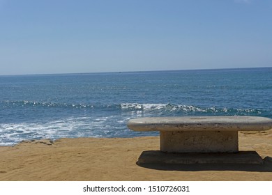 Empty bench by the ocean