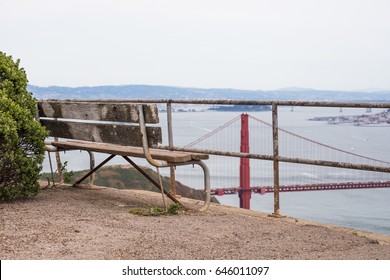 Empty bench standing on a cliff with a view of the bridge.