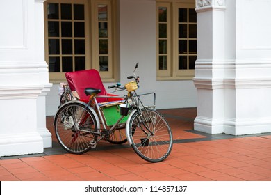 Empty Bicycle Rickshaw Near Classical Colonial Building, Singapore