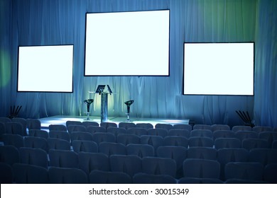 Empty Big Conference Hall With Podium And Three Screens