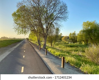 Empty Bike Trail Next To A Small Pond During Spring Sunset. 