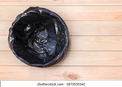 Empty Bin On Wooden Background. Trash Can Top View. Garbage Basket. Rubbish Black Bag In A Trash Can. Empty Rubbish Bin. Waste Can With Plastic Package. Empty Garbage Bin. Bin On Wooden Floor. Trash