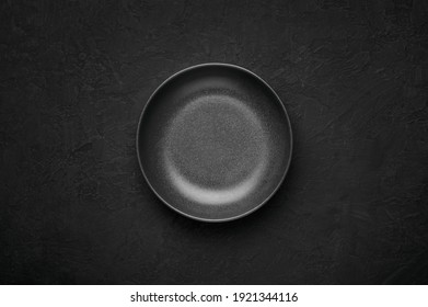 An Empty Black Bowl On Dark Slate Table Top. Rough Ceramic Bowl Background With Copy Space