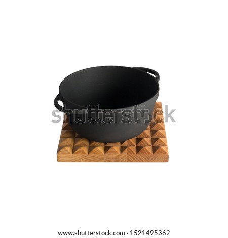 empty black iron cast cauldron, cast iron black pot, kettle cookware on a cutting board, isolated on perfect white background, stock photography  