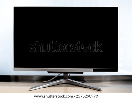Empty black LCD screen of modern computer monitor on the table isolated on white background in office. Blank black display of computer in workplace.
