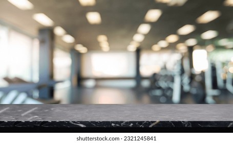 Empty black marble stone table top on blurred with bokeh Exercise room, fitness and gym interior background - can be used for display or montage your products