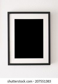 empty black picture frame on the wall