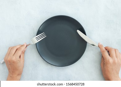 Empty Black Slate Plate On Grey Stone Table And Napkin. Food Background For Menu, Recipe. Table Setting. Flatlay, Top View. Mockup For Restaurant Dish