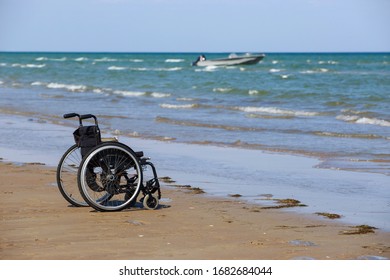 Empty black wheelchair stands on the seashore - Powered by Shutterstock