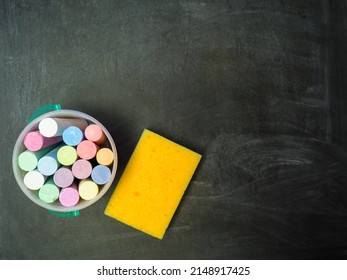Empty blackboard with colored chalks and sponge copy space