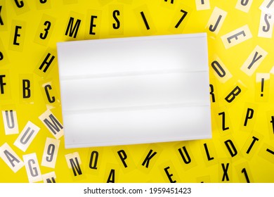 Empty Blank Lightbox With Copy Text Space For Message On Yellow Background With Black Alphabet Letters Randomly Scattered. Concept Of News, Advertising, Education, Literacy, Announcement, Banner