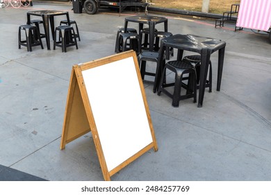 Empty blank for mockup sandwich chalkboard next to tables and chairs and a food truck in a square in Brazil - Powered by Shutterstock