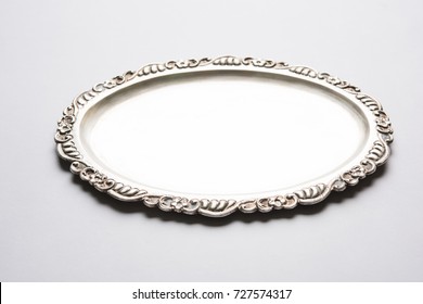 Empty Or Blank Silverware Or Oval Shape Silver Plate With Decorative Border, Isolated Over White Background, Selective Focus