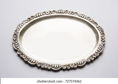 Empty Or Blank Silverware Or Oval Shape Silver Plate With Decorative Border, Isolated Over White Background, Selective Focus