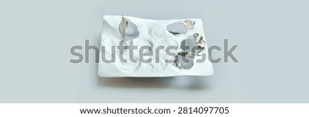 Empty blister pack with silver foil on light background signifying used medication.