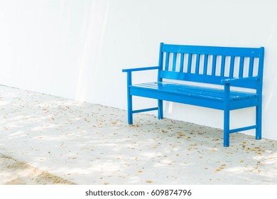 empty blue bench with white wall