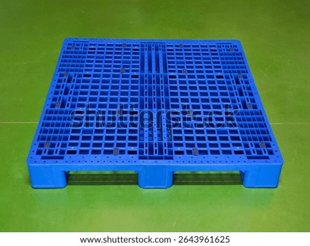 Empty Blue Plastic Pallet on Green Floor in Warehouse or Logistics Facility. High quality photo
