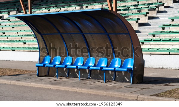 Empty blue plastic team players bench under\
shades in the stadium of football. Coach and reserve benches in a\
soccer field. Soccer bench seats. Russia, Saint-Petersburg, Kolpino\
12.04.2020. Editorial.