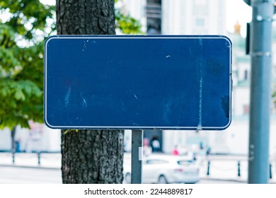 An empty blue rectangular road sign stands on the city's park. Information. Panel. Signpost. Traffic. Roadsign. Rectangular. Urban. Board. Destination. Metal. City. Border. Direction. Help