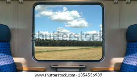An empty blue seat in europe german train with window corn field display nature summer view on the railway road transportation during coronavirus 