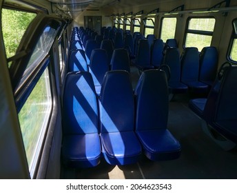 empty blue seats in a commuter train car. Empty electric train car in Russia. Interior of a suburban electric train in summer day