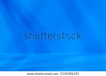 Empty blue studio space with deep artistic shadow. Minimalistic space concept
