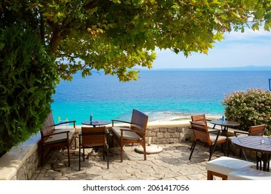 Empty blue tables at a Greek restaurant with a view to the Aegean Sea.