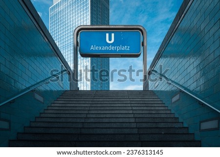 empty Blue tiled exit at Alexanderplatz metro station with communist-era high rise and blue sky
